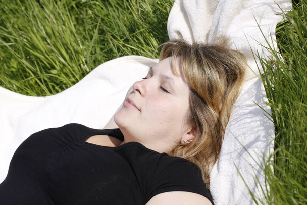 sleeping woman in a meadow in closeup - 写真・画像