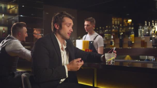 Homem se senta no bar e fala por link de vídeo no telefone
 - Filmagem, Vídeo