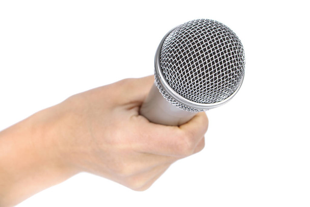 Silver microphone in a female hand on a white background. - Foto, Bild