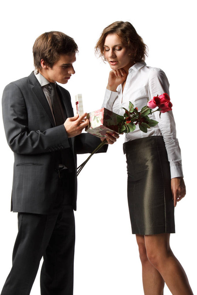 Genç aşık adam beyaz bir arka planda kız arkadaşına bir hediye verir.. - Fotoğraf, Görsel