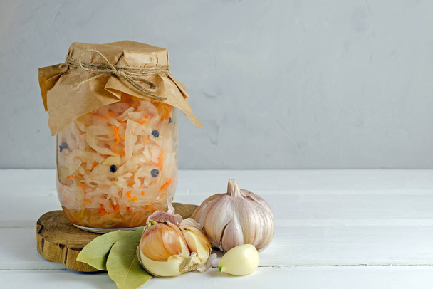 Fermented preserved vegetarian food concept. Homemade marinated cabbage with garlic and pepper, sauerkraut on white background. copy space. - Valokuva, kuva