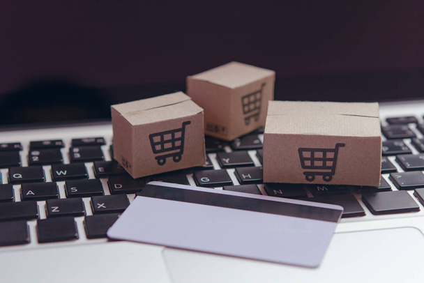 Online shopping - Paper cartons or parcel with a shopping cart l - Photo, Image