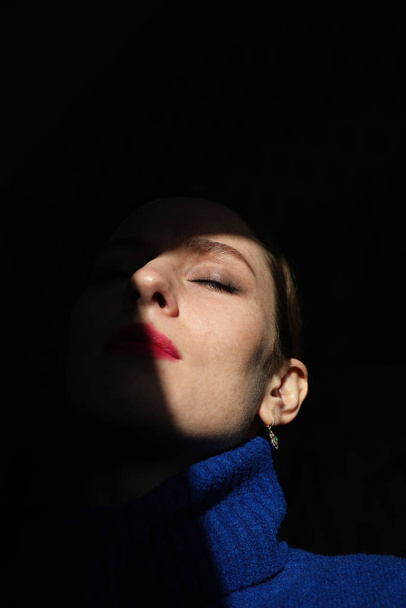 Creative portrait of young beautiful woman with red lips and closed eyes.  - Fotó, kép
