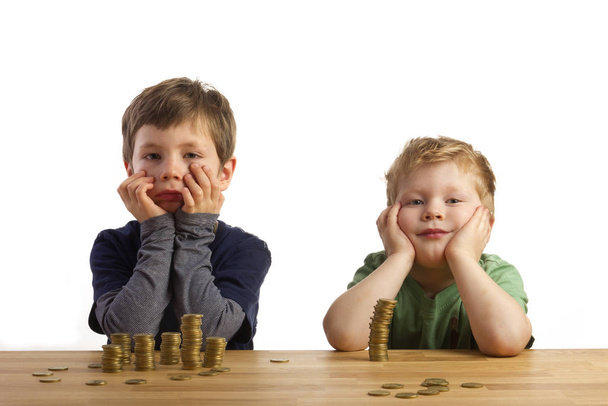two boys sitting thoughtfully money towers - Фото, зображення