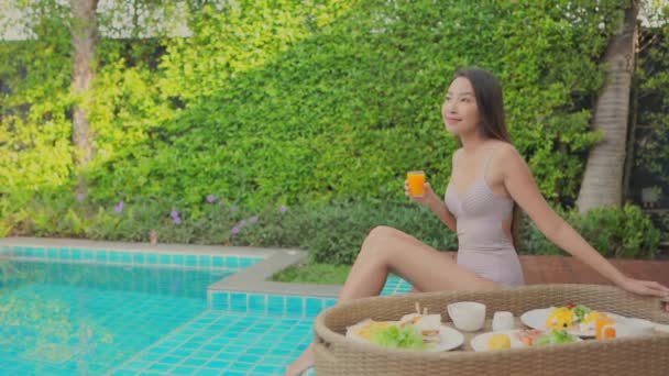 imagens de bela mulher asiática relaxante na piscina no hotel
 - Filmagem, Vídeo