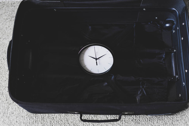 time to travel or delay during a trip,  empty suitcase with cloc - Foto, immagini