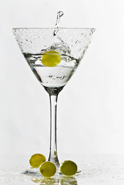 Vidrio de cóctel aislado sobre fondo blanco con uvas verdes - Foto, Imagen