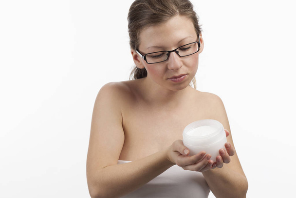 woman holds a cosmetic care product in hands - Foto, Bild