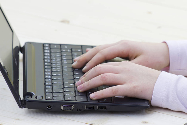 child hands typing on a keyboard of laptop  - Fotó, kép