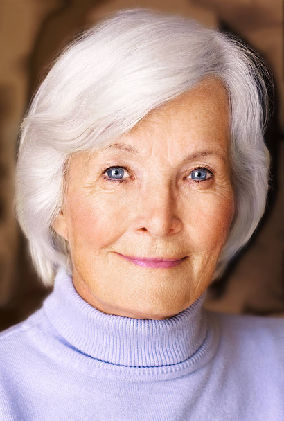 portrait of a senior woman on a gray background - Фото, изображение
