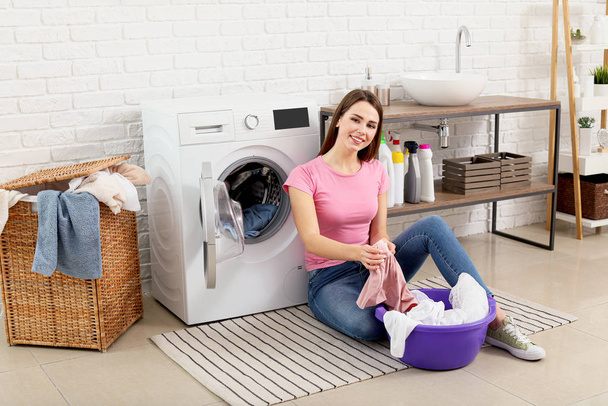 Jeune femme au foyer laver la lessive à la maison
 - Photo, image