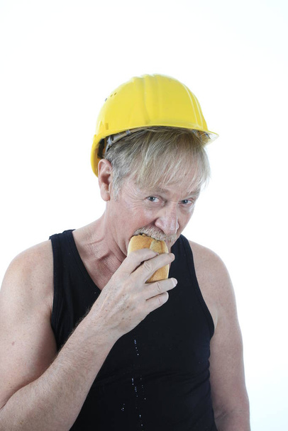 construction worker eating a bun - Foto, afbeelding