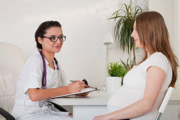 Pregnant woman visiting  doctor in clinic. - Photo, Image