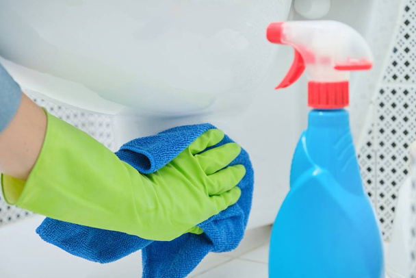 Close-up of hand in gloves with rag and detergent washing hanging toilet - Foto, immagini