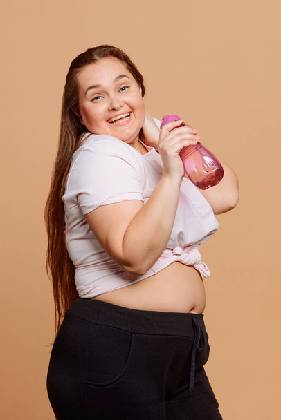 Funny overweight woman with a bottle of water - 写真・画像