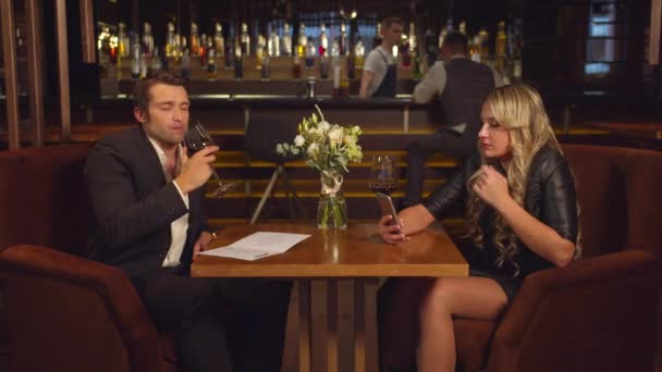 A férfi alkoholt iszik, és ránéz a nőjére, aki videokapcsolaton keresztül beszél.  - Felvétel, videó