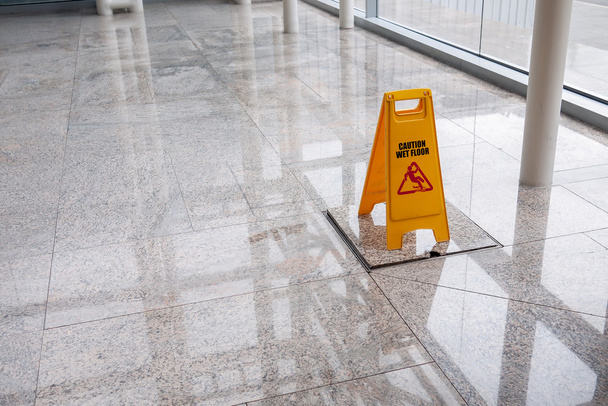 wet floor sign on lobby floor - Φωτογραφία, εικόνα