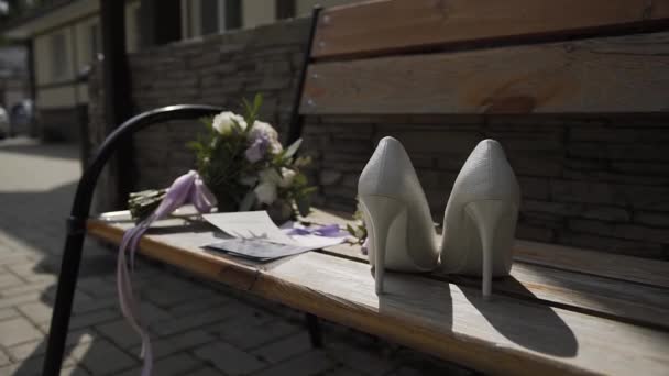 Bellissimi accessori da sposa da donna su una panchina. Giorno del matrimonio
. - Filmati, video