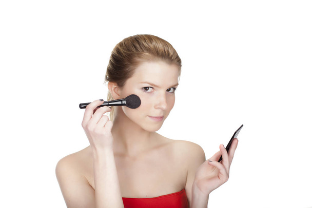 portrait of a young beautiful blond woman applying makeup freig - Foto, Imagem