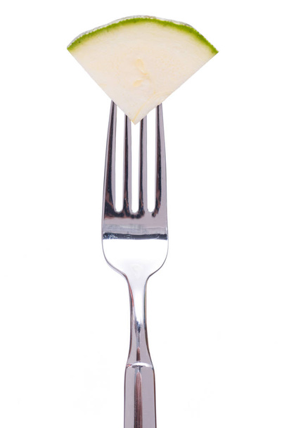 white isolated green zucchini on a fork - Fotó, kép