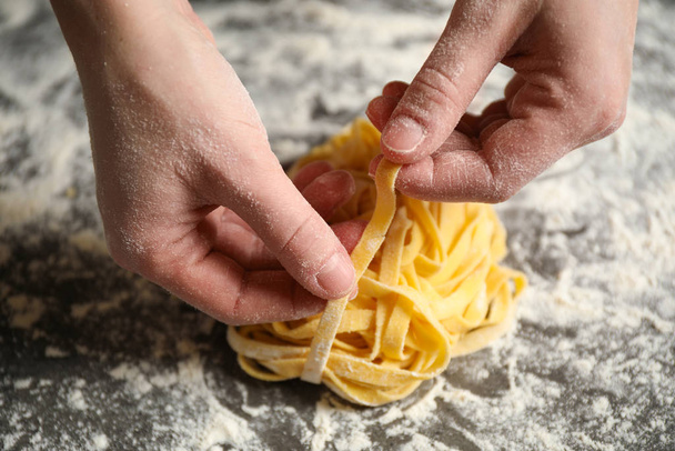 Woman holding pasta at table, closeup view - 写真・画像