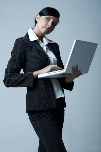 Beautiful brunette business woman with laptop computer isolated on clear background - Фото, зображення