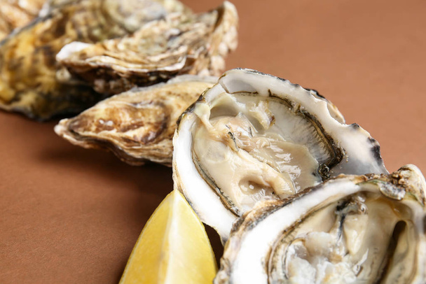 Tasty oysters with lemon on color background, closeup - Photo, Image
