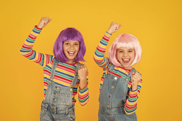 Anime convention. Anime cosplay party concept. Animation style characterized colorful graphics vibrant characters fantastical themes. Happy little girls. Anime fan. Cheerful friends in colorful wigs - Foto, imagen