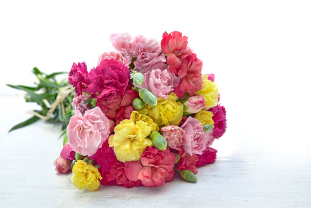 beautiful bouquet of colorful flowers carnation on a white table  - Fotó, kép
