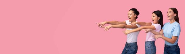 Three Excited Girls Pointing Fingers Aside Over Pink Background, Panorama - Valokuva, kuva