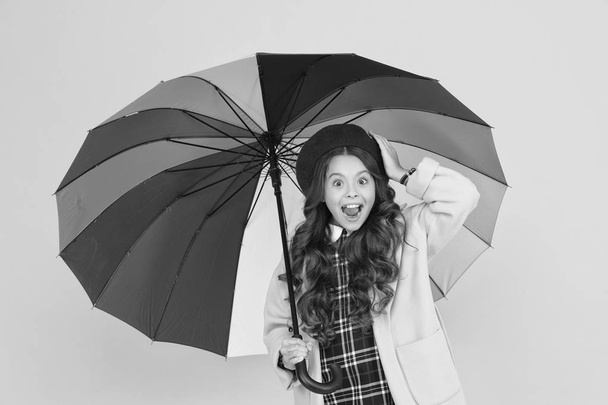 Bright umbrella. Have fun. Positivity concept. Rainy day fun. Happy walk under umbrella. Enjoy rain concept. Kid girl happy hold colorful rainbow umbrella. Rainy weather with proper garments - Photo, image