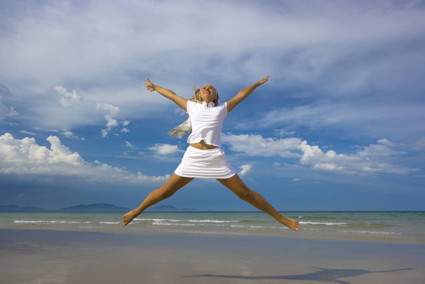 Young woman jumping on the tropical beach - Photo, image