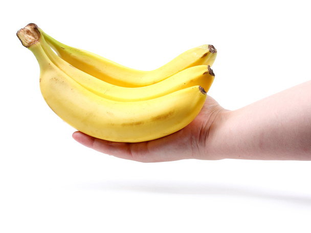 bos van rijpe bananen in vrouwelijke hand - Foto, afbeelding