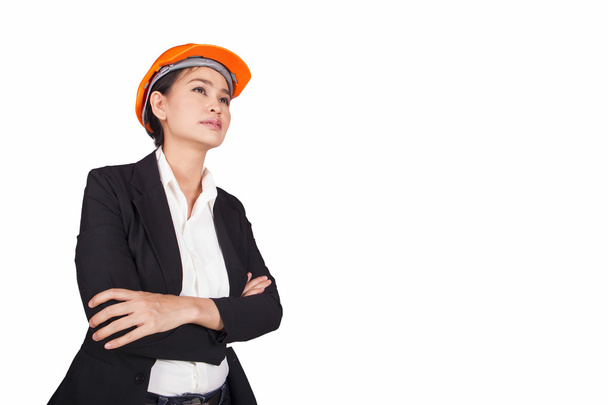 Engineer woman crossed her arms over her chest is an orange helmet on her head - Foto, Imagen