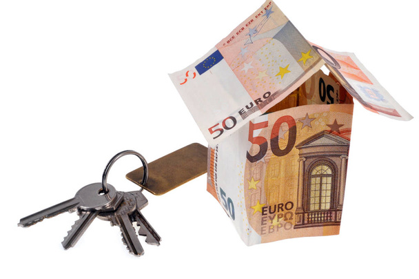 Dům v eurobankovkách s svazkem klíčů na bílém pozadí  - Fotografie, Obrázek