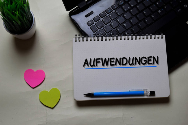 Οι Aufwendungen γράφουν σε ένα βιβλίο που είναι απομονωμένο στο γραφείο. Γερμανική γλώσσα σημαίνει λειτουργικά έξοδα - Φωτογραφία, εικόνα