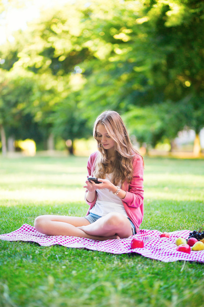 Girl using her mobile phone outdoors - Foto, imagen
