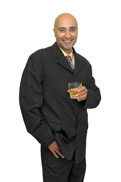 Empresario con una copa de whisky aislada de blanco - Foto, Imagen