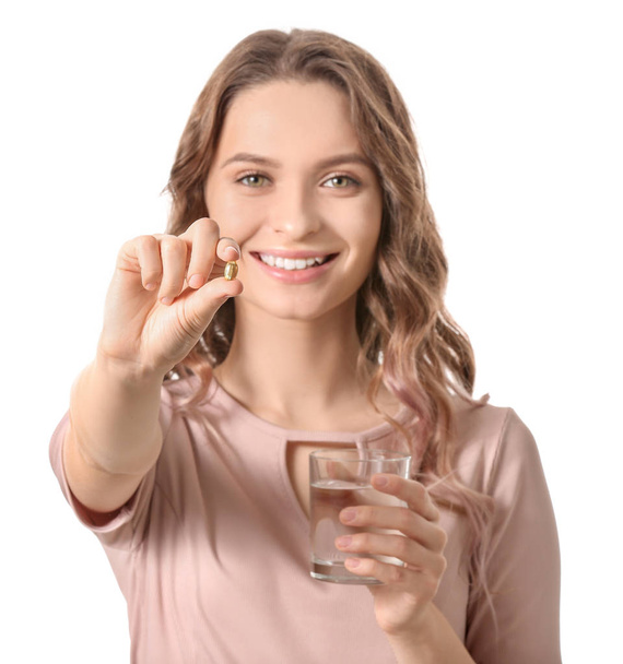 Young woman with fish oil on white background - Valokuva, kuva