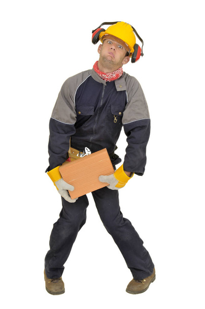 Worker trying to lift a heavy brick isolated in white - Foto, Imagem