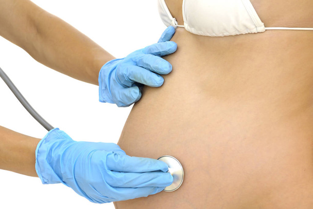 Pregnant woman belly with doctor's hands measuring blood pressure isolated in white - Photo, Image