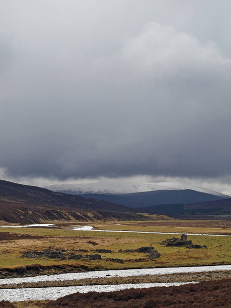 Ciężkie ciemne chmury nad Cairngorms, z ruinami na pierwszym planie.   - Zdjęcie, obraz