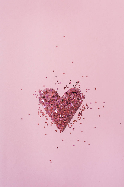 Herz-Symbol aus Funkeln auf rosa Hintergrund. flach, von oben betrachtet Valentinstag minimales Urlaubskonzept. - Foto, Bild