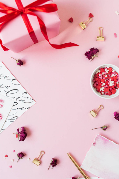 Kopiuj przestrzeń makieta rama wykonana z świątecznych dekoracji na różowym tle. Flatlay, widok z góry Walentynki kompozycja wakacje. - Zdjęcie, obraz