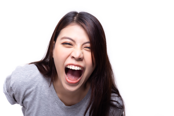 Une femme asiatique en riant. Une jeune fille asiatique rigole avec moquerie ou raillerie. La jeune femme est joyeuse. Elle entend la blague histoire et rire beaucoup, elle ne peut pas arrêter de rire. studio sur blanc - Photo, image
