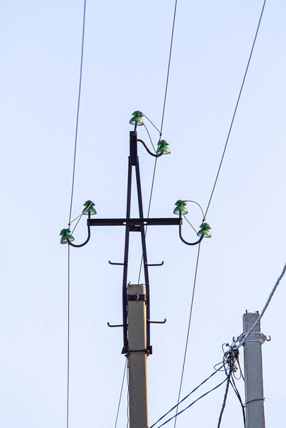 Un pilar con cables contra un cielo azul
. - Foto, imagen