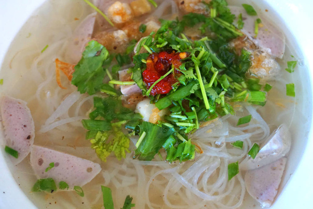 Вьетнамский суп из лапши со свиной говядиной, нарезанной рыбой, жареным луком, свежей холодной травой и овощами, Фо Бо Ху Тьё, азиатская кухня, традиционные блюда
  - Фото, изображение