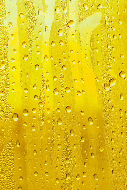 ガラス上の水滴、黄色の背景ビール、曇っの背景. - 写真・画像