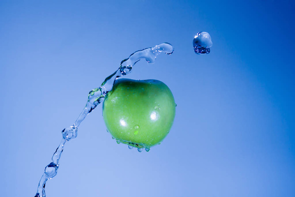 Ein Apfel welcher mit Wasser beworfen wird - Foto, imagen