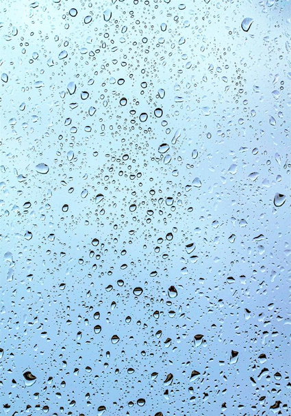 Gotas de chuva no vidro, fundo azul escuro do céu fora da janela
. - Foto, Imagem